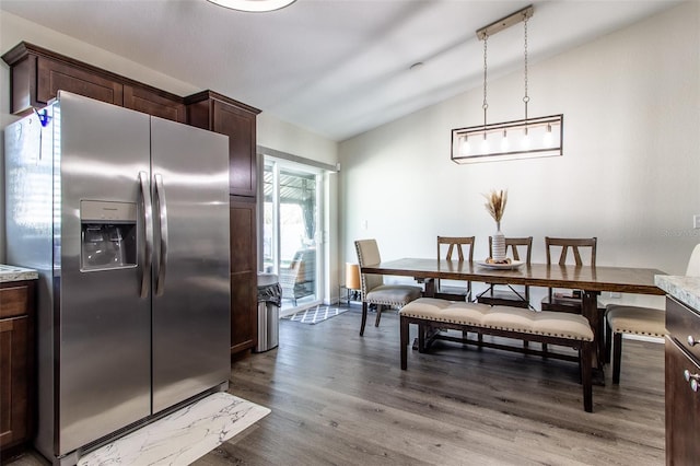 dining room featuring hardwood / wood-style floors and lofted ceiling