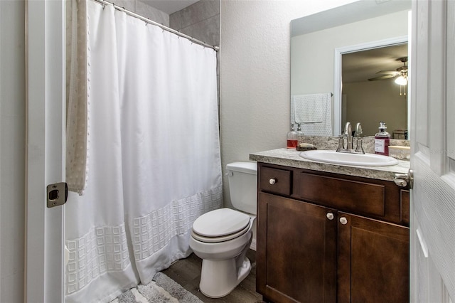 bathroom with hardwood / wood-style floors, vanity, toilet, and ceiling fan