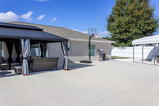 rear view of property with a gazebo, an outdoor hangout area, and a patio area