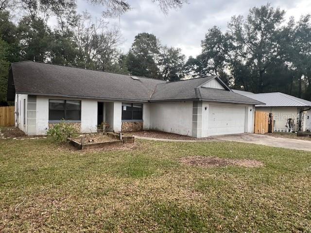 ranch-style house with a garage and a front lawn