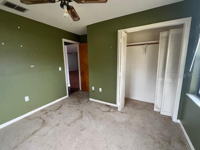 unfurnished bedroom with ceiling fan, light carpet, and a closet