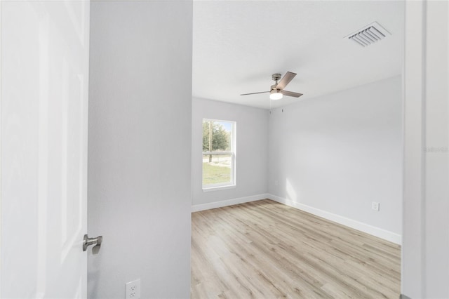 empty room featuring ceiling fan, light wood-type flooring, visible vents, and baseboards