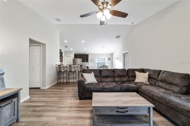 living room with vaulted ceiling, ceiling fan, and light hardwood / wood-style floors