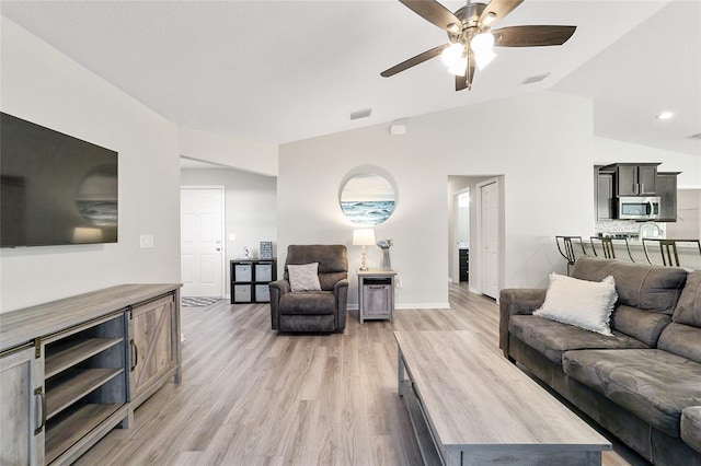 living room featuring light hardwood / wood-style floors, lofted ceiling, and ceiling fan