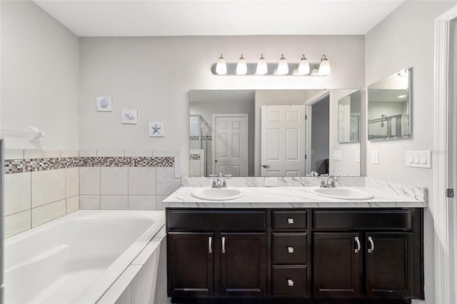 bathroom featuring tiled bath and vanity