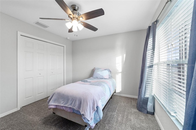 bedroom with ceiling fan, a closet, multiple windows, and carpet flooring