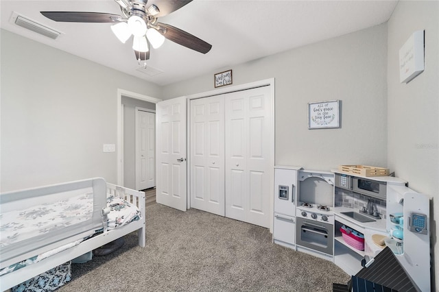 carpeted bedroom featuring ceiling fan and a closet