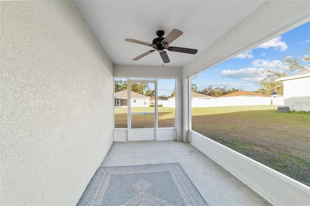 unfurnished sunroom with ceiling fan