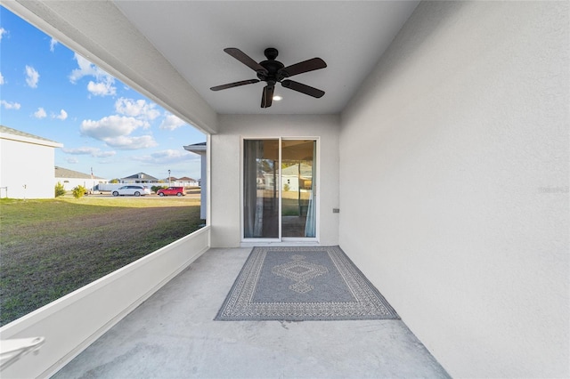 property entrance with ceiling fan and a lawn