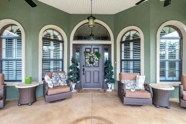 view of exterior entry featuring covered porch and ceiling fan