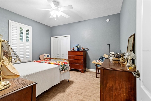 carpeted bedroom with ceiling fan and a closet