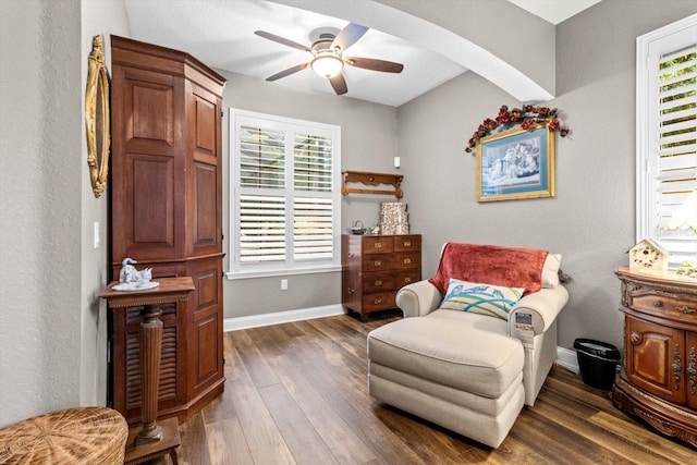 living area with ceiling fan, a healthy amount of sunlight, and dark hardwood / wood-style flooring