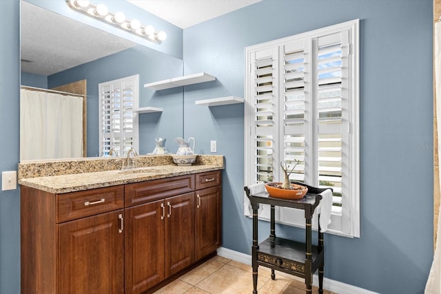 bathroom featuring a textured ceiling, vanity, and tile patterned floors