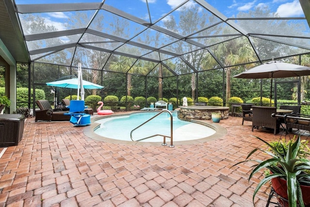 view of pool with a patio area, an in ground hot tub, and glass enclosure