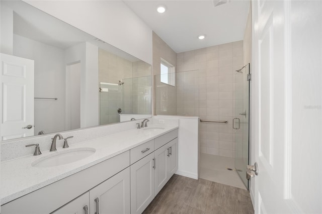 bathroom featuring hardwood / wood-style floors, vanity, and an enclosed shower