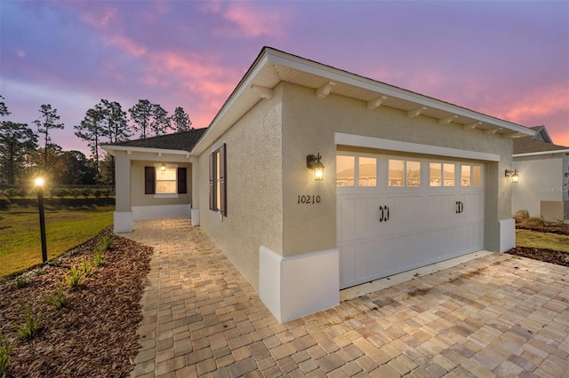 property exterior at dusk featuring a garage