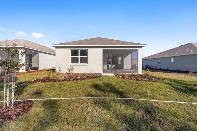 back of property with a lawn and a sunroom