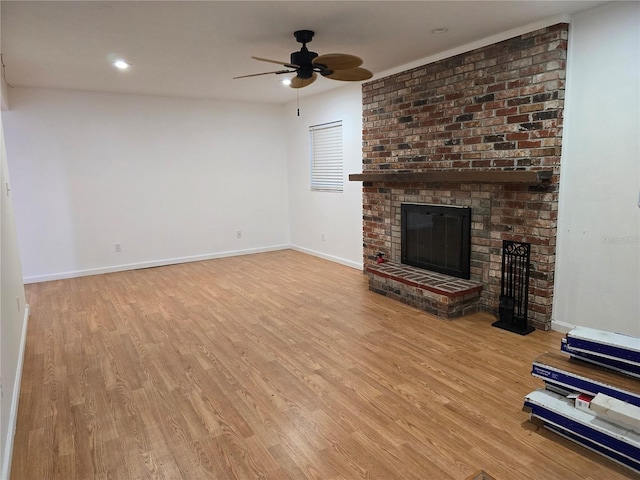 unfurnished living room with ceiling fan, light hardwood / wood-style floors, and a fireplace