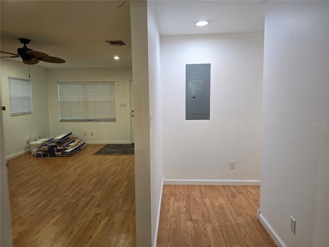 corridor with light wood-type flooring and electric panel