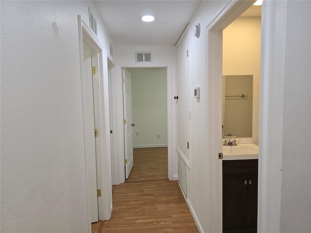 hall with sink and light hardwood / wood-style floors