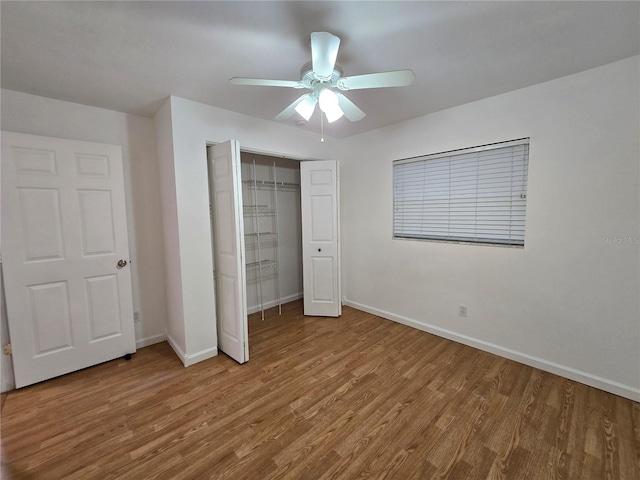 unfurnished bedroom featuring ceiling fan, wood-type flooring, and a closet