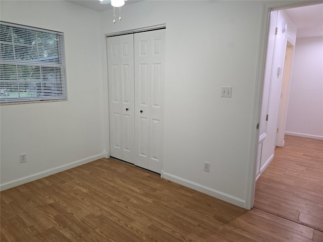 unfurnished bedroom with hardwood / wood-style floors and a closet