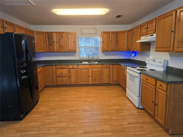 kitchen with light wood-type flooring, black fridge with ice dispenser, electric range, and sink