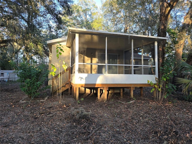 back of property with a sunroom