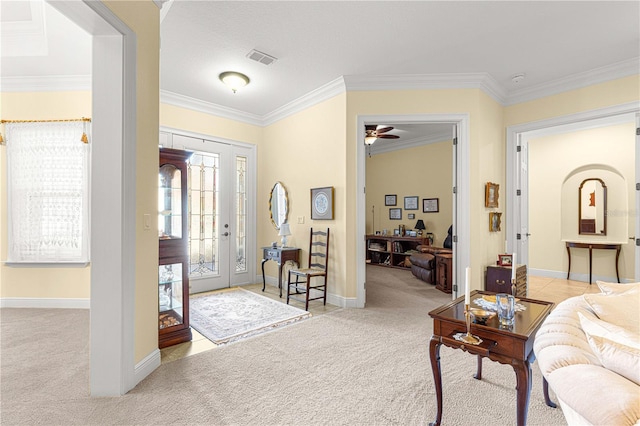 foyer with ceiling fan, ornamental molding, and light carpet