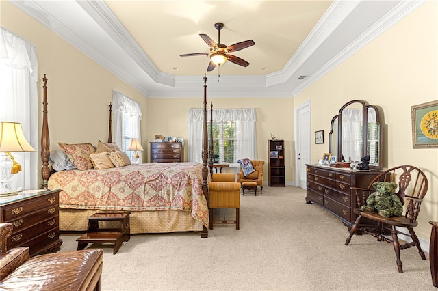 bedroom with a raised ceiling, ceiling fan, crown molding, and light colored carpet