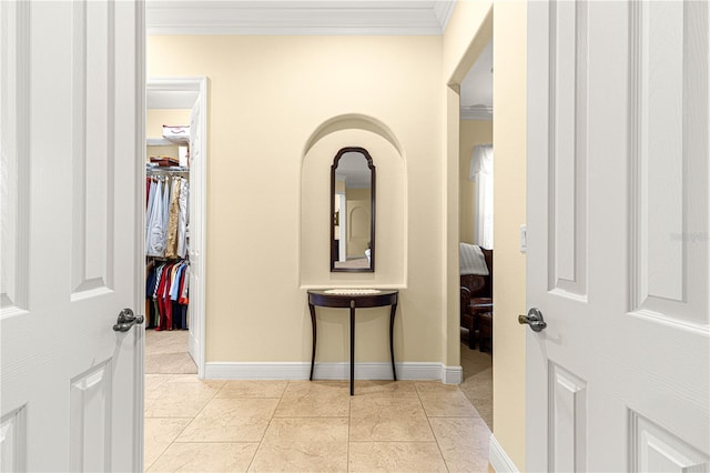 hall featuring light tile patterned floors and crown molding