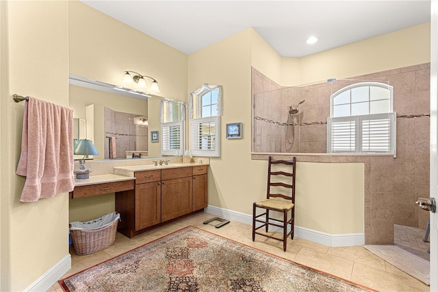 bathroom with tiled shower, vanity, and tile patterned floors