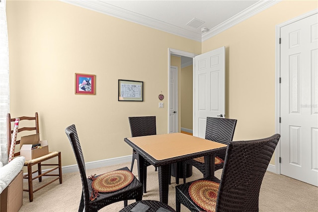 dining room with crown molding and light colored carpet