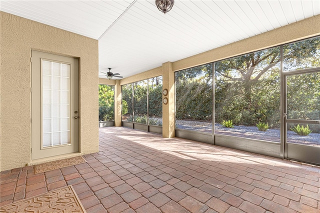 unfurnished sunroom with ceiling fan