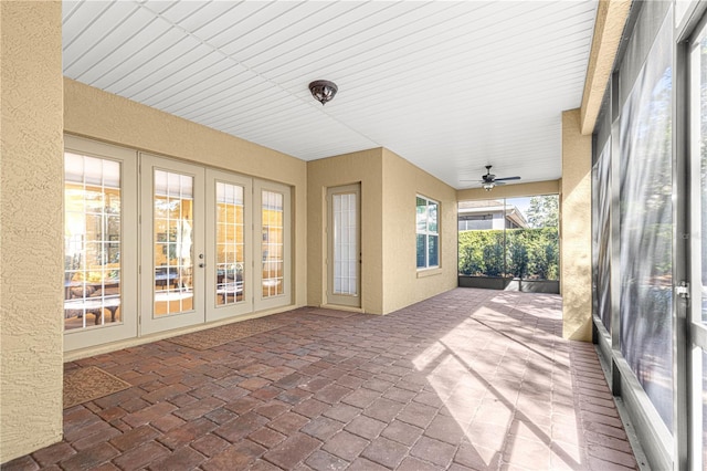 unfurnished sunroom with ceiling fan and french doors