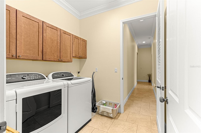 washroom with cabinets, washing machine and dryer, ornamental molding, and light tile patterned flooring