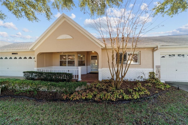 ranch-style house with a porch and a garage