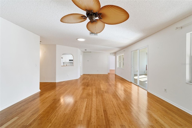 unfurnished room featuring a textured ceiling, light wood-type flooring, and ceiling fan