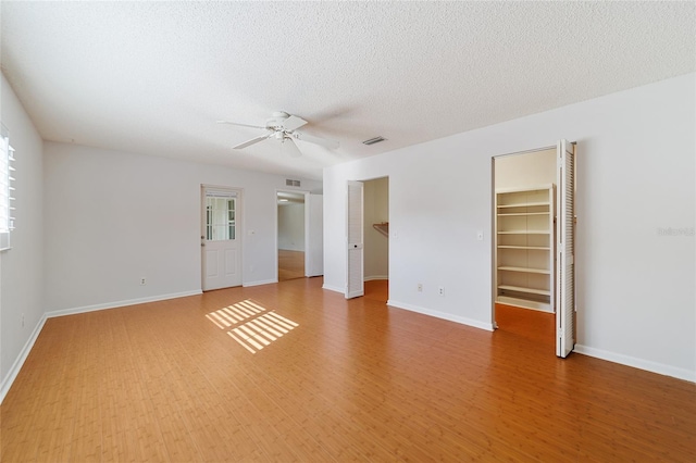 unfurnished room featuring ceiling fan, hardwood / wood-style floors, and a textured ceiling