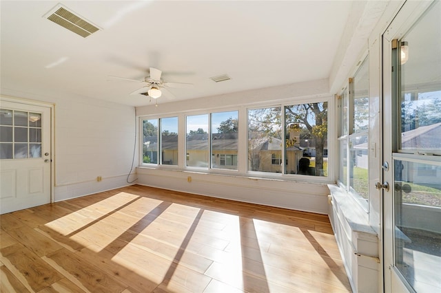 unfurnished sunroom with ceiling fan