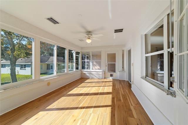 unfurnished sunroom with ceiling fan