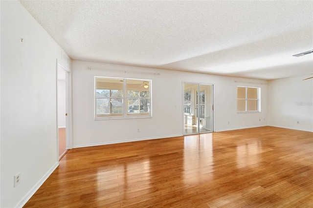 spare room with ceiling fan, a textured ceiling, and light hardwood / wood-style flooring