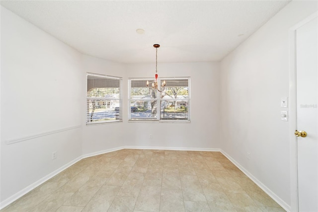 spare room featuring an inviting chandelier