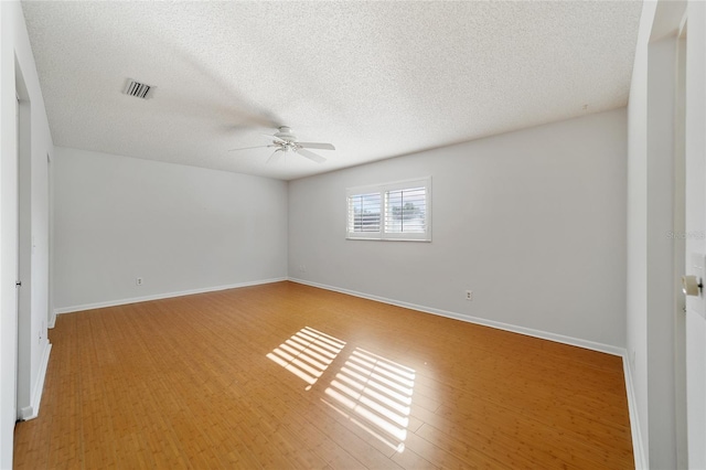 spare room featuring ceiling fan, light hardwood / wood-style floors, and a textured ceiling