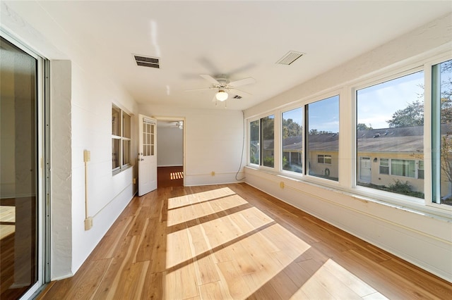 unfurnished sunroom with ceiling fan