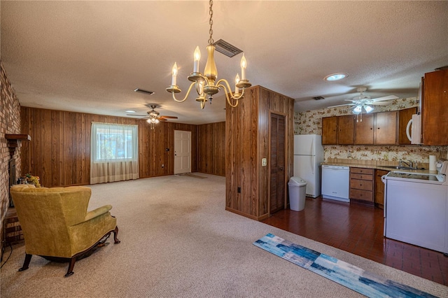 kitchen with ceiling fan with notable chandelier, pendant lighting, white appliances, and a textured ceiling