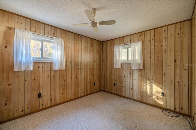 empty room featuring ceiling fan, light colored carpet, and a textured ceiling