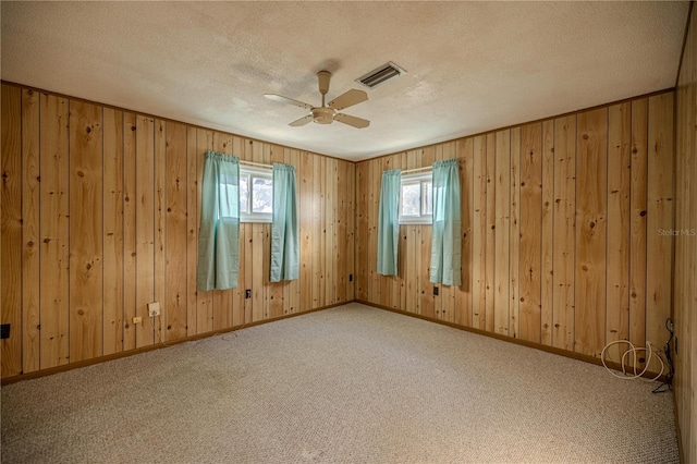 carpeted empty room with ceiling fan and a textured ceiling