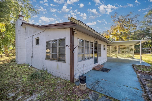 view of side of home with a carport