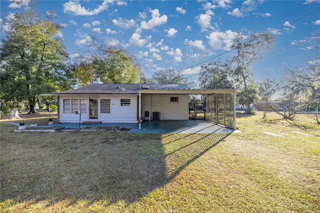 back of property featuring a carport, cooling unit, and a lawn